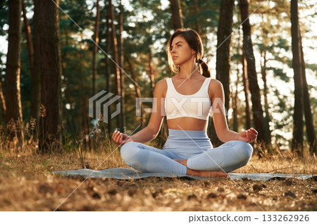 Time for calm meditation. Woman is doing yoga fitness exercises in the forest 133262926
