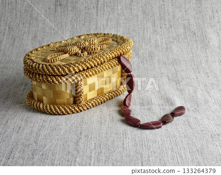Natural stone, irregularly shaped red jasper beads in a wicker basket. Burlap background 133264379