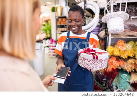 Florist accepting payment using NFC technology on smartphone in flower shop 133264648