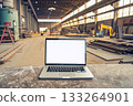 An open laptop in mechanical metal processing shop, in warehouse 133264901