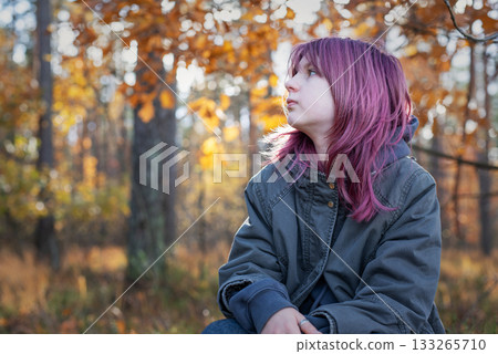 Teen girl with purple hair contemplating in autumn forest 133265710