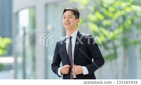 Motivated male businessman walking through an office district Motivated male businessman walking through an office district 133265938
