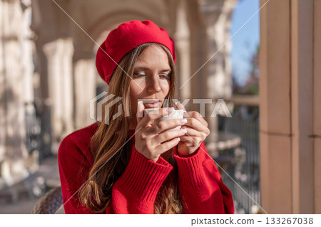 Woman Coffee Beret: Day view of woman enjoying coffee at outdoor cafe due relaxation. Woman Coffee Beret: Day view of woman enjoying coffee at outdoor cafe due relaxation. 133267038