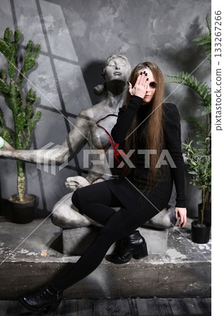 Mysterious woman in studio with sculpture and contrasting shadows 133267266