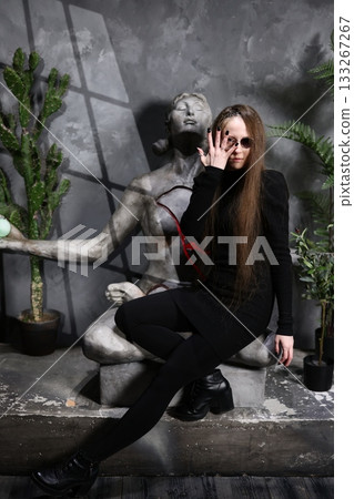 Female specialist meticulously adjusts her eyewear near historic art piece 133267267