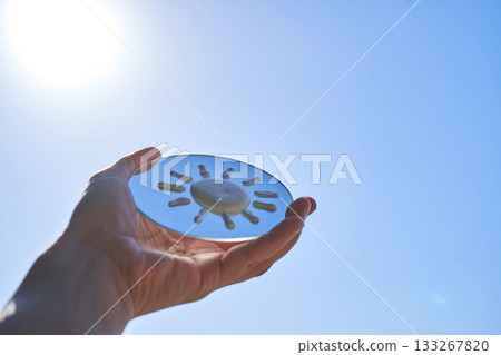 Hand holding mirror reflecting sunscreen sun protection 133267820