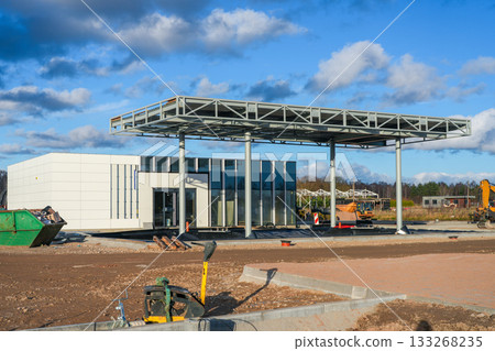 Construction of a modern gas station with steel canopy and service building in final stages Construction of a modern gas station with steel canopy and service building in final stages 133268235