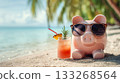 A pink piggy bank in sunglasses relaxes on a tropical beach with a cold cocktail. The concept of saving for a vacation, financial planning, money, summer resort 133268564