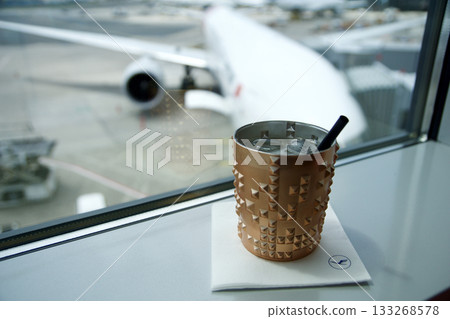 Frankfurt, Germany, June 10, 2019: Moscow Mule Cocktail with View of Long Haul Aircraft at the Gate 133268578