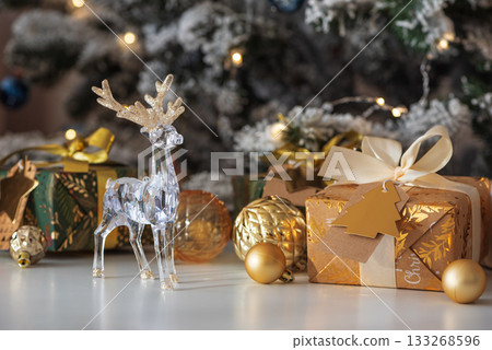 Crystal Reindeer with Gold Antlers and Christmas Gifts in Festive Interior 133268596
