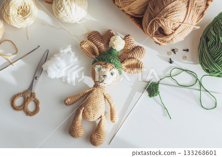 Crocheted Reindeer Toy with Yarn and Crafting Tools in Cozy Workspace 133268601