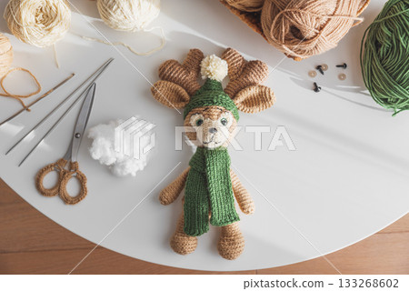 Crocheted Reindeer Toy with Yarn and Crafting Tools in Cozy Workspace Crocheted Reindeer Toy with Yarn and Crafting Tools in Cozy Workspace 133268602