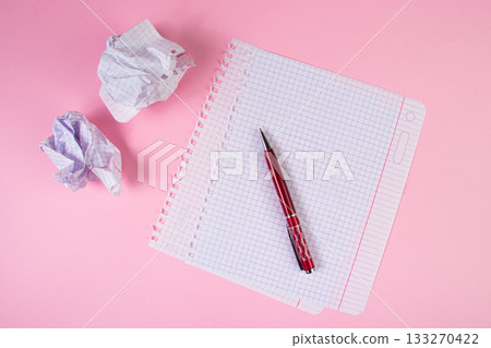 Blank paper and crumpled paper wads on a pink background. Symbol of writing. Search for inspiration, writing plans. Education or business concept. Blank paper and crumpled paper wads on a pink background. Symbol of writing. Search for inspiration, writing plans. Education or business concept. 133270422