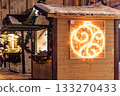 Christmas street market. Wooden houses for selling Christmas decorations and toys. Winter holiday season. 133270433