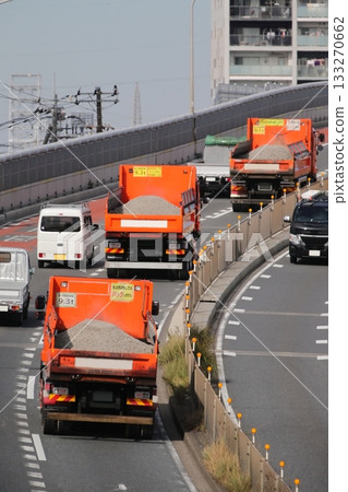 Dump trucks traveling in a line 133270662