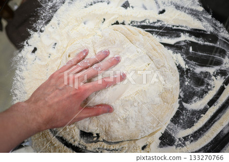 Making Fresh Yeast Dough by Hand with Flour on Kitchen Table, Close Up Process Making Fresh Yeast Dough by Hand with Flour on Kitchen Table, Close Up Process 133270766