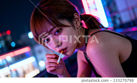 夜裡，一名女子在城市裡抽菸。 133270798