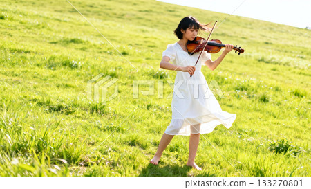 草地上拉小提琴的女人 133270801