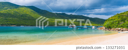 white sandy beach on a tropical island in a bay by the sea on a summer. Luxury exotic resort with a beach. Landscape panorama with a view of the coast by ocean white sandy beach on a tropical island in a bay by the sea on a summer. Luxury exotic resort with a beach. Landscape panorama with a view of the coast by ocean 133271031