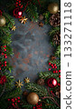 Frame of Christmas tree branches and decorations, pine cones and the balls are gold and green. Copy place 133271118