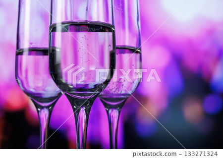 stylish stemmed glasses highlight effervescent drinks amidst colorful neon lighting for nightlife promotion 133271324