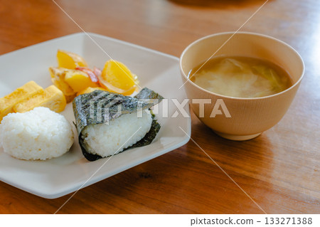 日式早餐包括飯糰、玉子燒(捲蛋)、炸馬鈴薯和味噌湯 日式早餐包括飯糰、玉子燒(捲蛋)、炸馬鈴薯和味噌湯 133271388