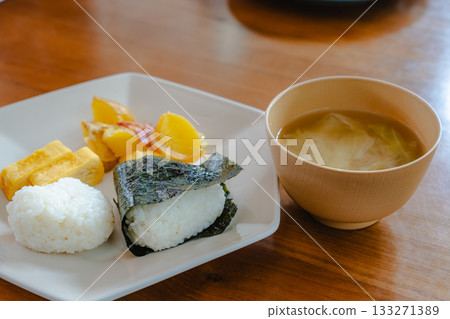 日式早餐包括飯糰、玉子燒(捲蛋)、炸馬鈴薯和味噌湯 日式早餐包括飯糰、玉子燒(捲蛋)、炸馬鈴薯和味噌湯 133271389