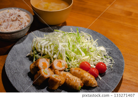 A home-style dinner of pork wrapped in vegetables, shredded cabbage, mixed grain rice, and miso soup A home-style dinner of pork wrapped in vegetables, shredded cabbage, mixed grain rice, and miso soup 133271407