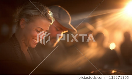 Close-up of a happy woman smiling, warmly backlit by golden hour sun. The scene evokes intimacy and joy. Ideal for lifestyle, relationship, or travel-themed projects. 133271505