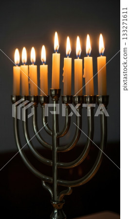 A classic Hanukkah menorah with all nine candles lit, glowing against a simple dark background. This clean image captures the quiet, spiritual moment of the holiday ritual of faith. A classic Hanukkah menorah with all nine candles lit, glowing against a simple dark background. This clean image captures the quiet, spiritual moment of the holiday ritual of faith. 133271611
