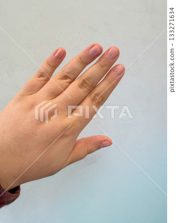 Close-up of a female hand with natural nude manicure on a light background, clean nails and simple minimal beauty style 133271634