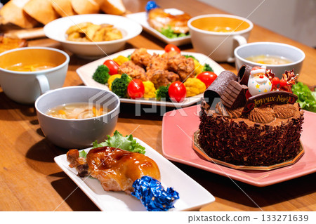 一張精美的餐桌上擺放著聖誕烤雞、炸雞花圈和蛋糕。 133271639