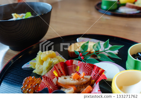 A gorgeous New Year's dinner table with ozoni and osechi dishes arranged on a half-moon tray A gorgeous New Year's dinner table with ozoni and osechi dishes arranged on a half-moon tray 133271762