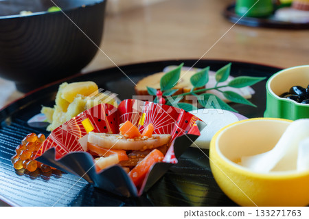 A gorgeous New Year's dinner table with ozoni and osechi dishes arranged on a half-moon tray A gorgeous New Year's dinner table with ozoni and osechi dishes arranged on a half-moon tray 133271763