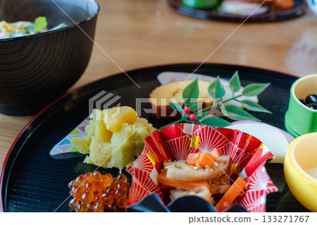 A gorgeous New Year's dinner table with ozoni and osechi dishes arranged on a half-moon tray A gorgeous New Year's dinner table with ozoni and osechi dishes arranged on a half-moon tray 133271767