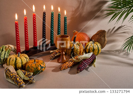 Kwanzaa Celebration Setup. Vibrant Kwanzaa scene with candles, colorful squash, maize, chalice, Kwanzaa Celebration Setup. Vibrant Kwanzaa scene with candles, colorful squash, maize, chalice, 133271794