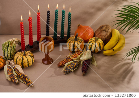 Festive Kwanzaa Setting. A warm Kwanzaa scene with a kinara, fruits, and vegetables 133271800
