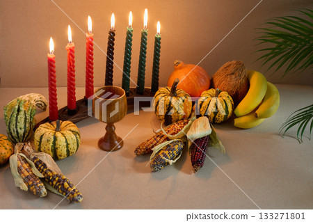 Festive Kwanzaa Setting. A warm Kwanzaa scene with a kinara, fruits, and vegetables 133271801