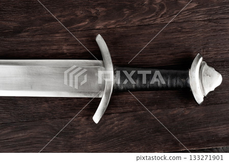 Viking sword on wooden table. 133271901