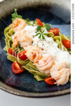 Gourmet spinach tagliatelle with shrimp, burrata and cherry tomatoes in ceramic bowl Gourmet spinach tagliatelle with shrimp, burrata and cherry tomatoes in ceramic bowl 133272006