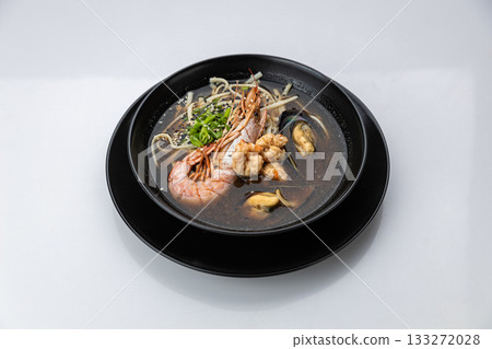 Seafood ramen with prawn, mussels and noodles in soy broth, black bowl on white background Seafood ramen with prawn, mussels and noodles in soy broth, black bowl on white background 133272028