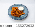 Crispy sweet potato fries with creamy dip on a blue ceramic plate, overhead food photo 133272032