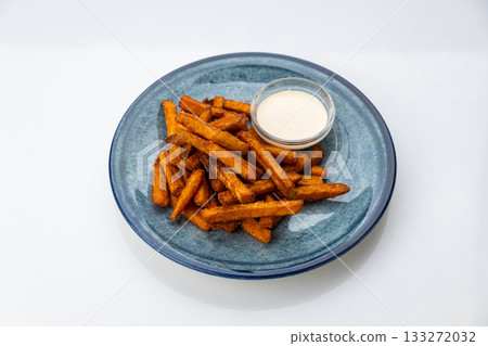 Crispy sweet potato fries with creamy dip on a blue ceramic plate, overhead food photo Crispy sweet potato fries with creamy dip on a blue ceramic plate, overhead food photo 133272032