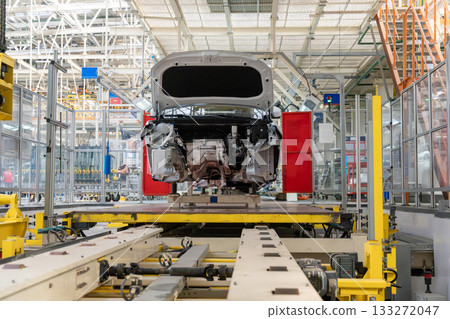A modern, high-tech automotive assembly line with a white car body chassis A modern, high-tech automotive assembly line with a white car body chassis 133272047