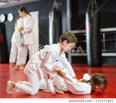 Boy and girl train judo in pairs 133272863