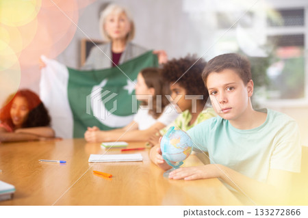 Female teacher showing pakistani flag to kids in geography class Female teacher showing pakistani flag to kids in geography class 133272866