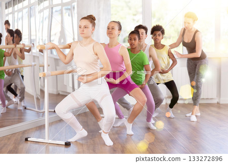 Teenage girl practicing plie position of ballet during choreography classes 133272896