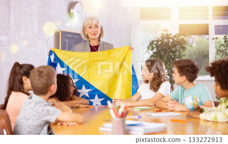 Mature female teacher tells pupils the history of Bosnia and Herzegovina 133272913