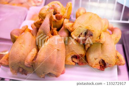 Refrigerated display case contains whole chilled chicken carcasses 133272917