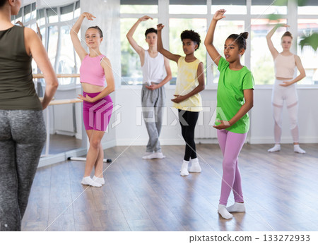 Teenage African American girl practicing ballet moves at group class Teenage African American girl practicing ballet moves at group class 133272933